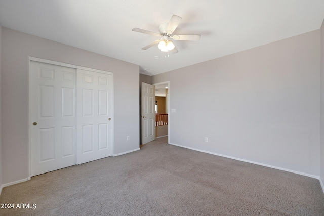 unfurnished bedroom with a closet, carpet flooring, and ceiling fan