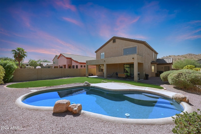 pool at dusk with a patio area