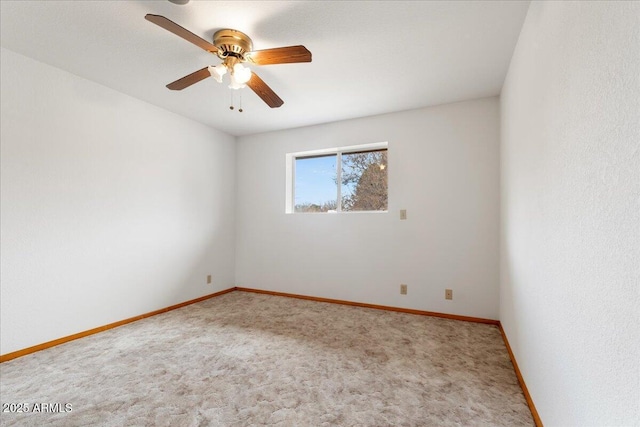 unfurnished room featuring carpet floors, baseboards, and a ceiling fan