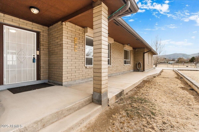 property entrance featuring brick siding and a mountain view