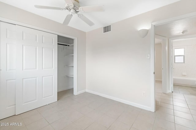 unfurnished bedroom with baseboards, visible vents, light tile patterned flooring, ceiling fan, and a closet