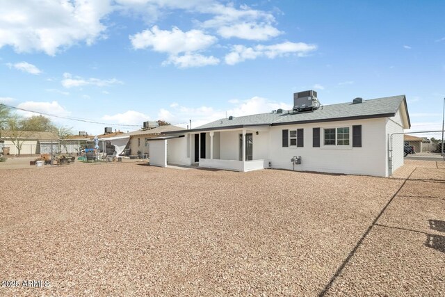 back of property featuring central AC and fence