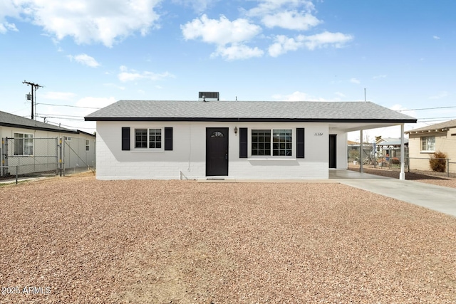 single story home with an attached carport, fence, driveway, and roof with shingles