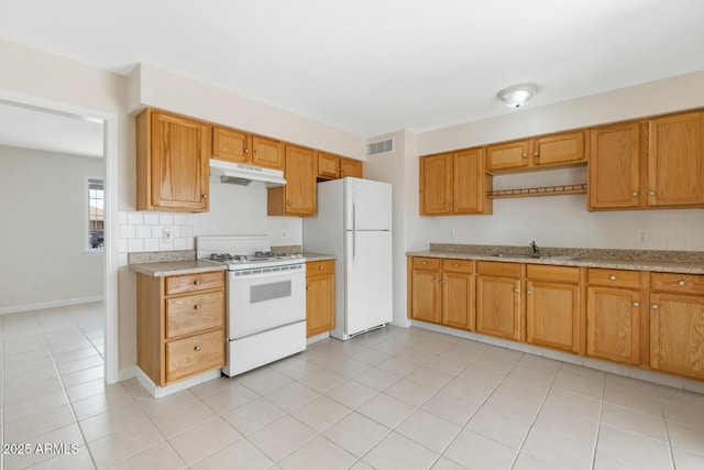 kitchen with visible vents, under cabinet range hood, brown cabinets, white appliances, and a sink