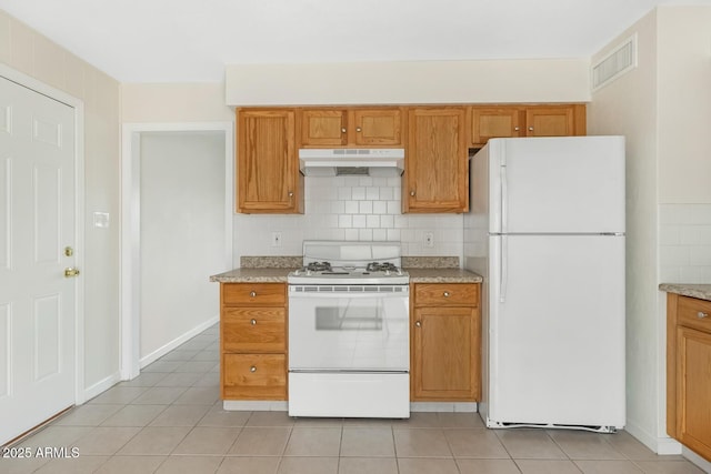 kitchen featuring under cabinet range hood, visible vents, white appliances, and backsplash