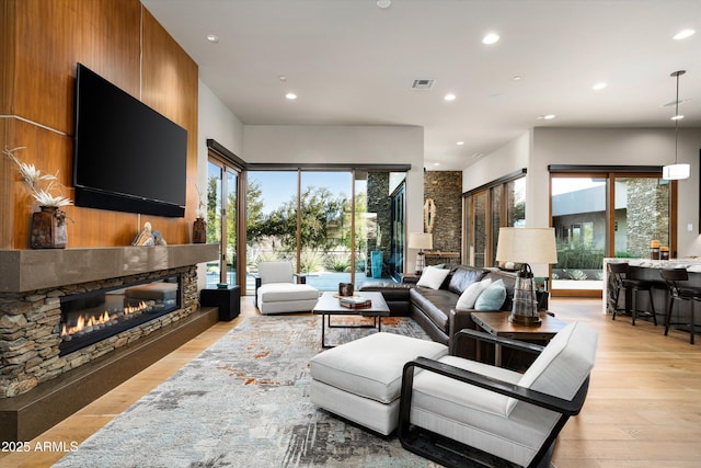 living room featuring plenty of natural light, a fireplace, and light hardwood / wood-style flooring