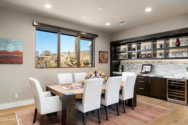 dining space featuring wine cooler and light hardwood / wood-style floors