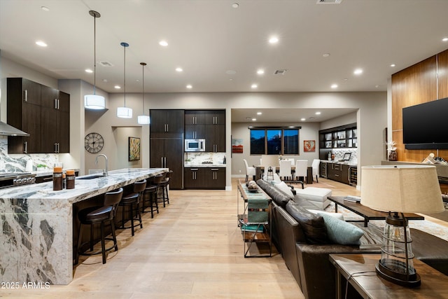 living room featuring sink and light hardwood / wood-style floors