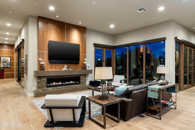 living room featuring a fireplace and light wood-type flooring