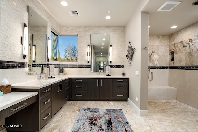 bathroom featuring walk in shower, vanity, and decorative backsplash