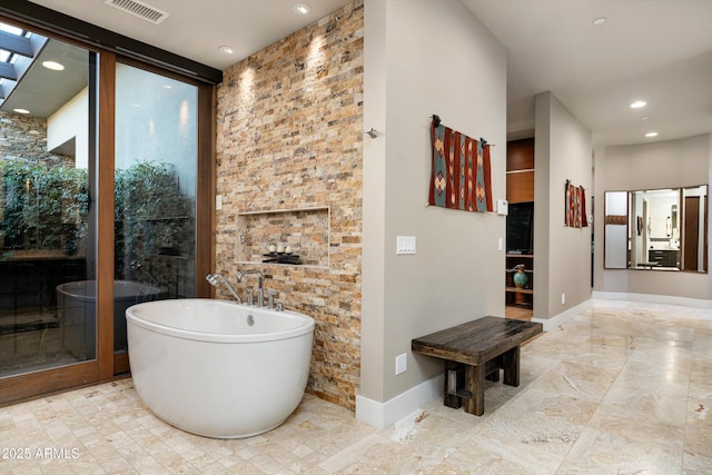 bathroom featuring a tub and a wall of windows