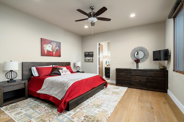 bedroom featuring ensuite bath, light hardwood / wood-style floors, and ceiling fan