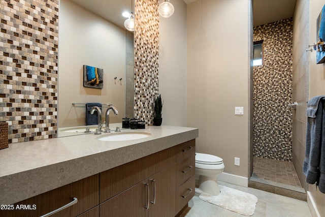 bathroom featuring toilet, tasteful backsplash, a tile shower, vanity, and tile patterned flooring