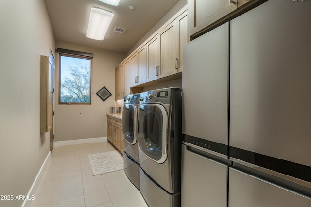 clothes washing area featuring washing machine and dryer and cabinets