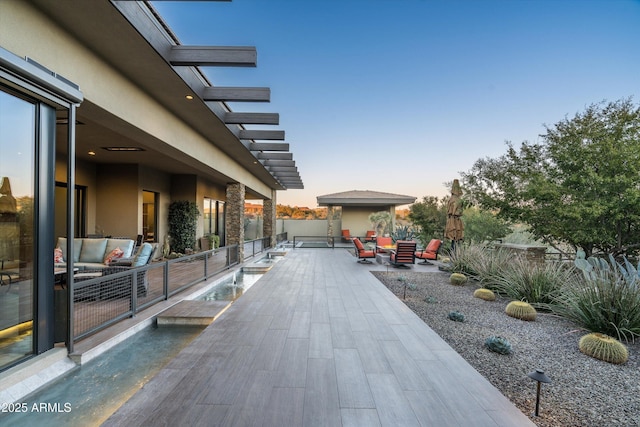 patio terrace at dusk featuring outdoor lounge area