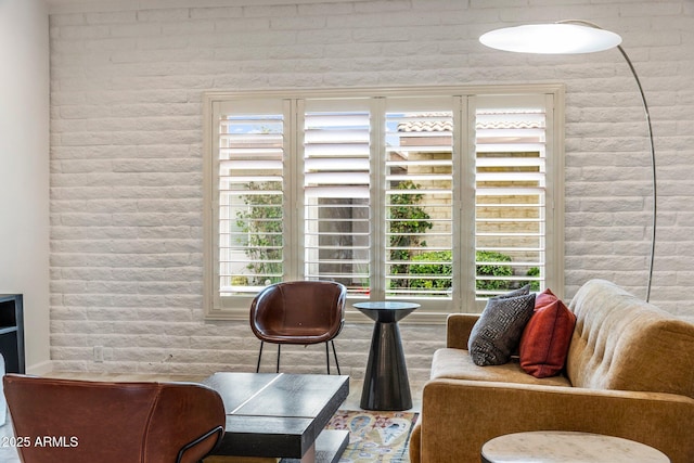 living area with brick wall and plenty of natural light