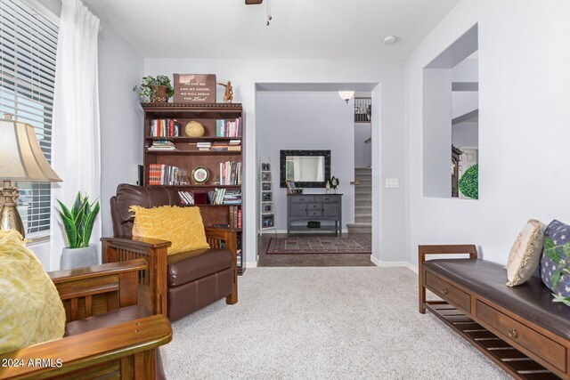 sitting room featuring ceiling fan and light carpet