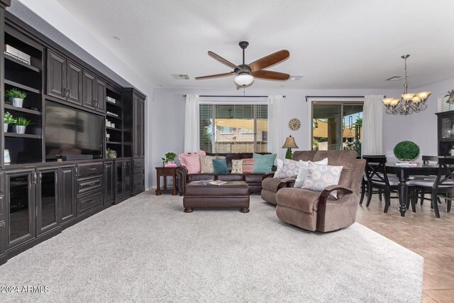 living room with ceiling fan with notable chandelier