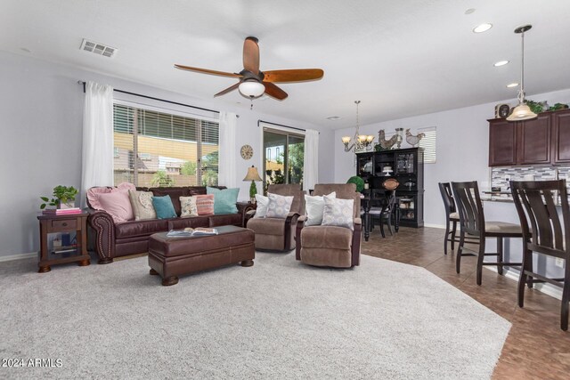 tiled living room featuring ceiling fan with notable chandelier