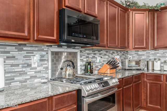 kitchen featuring light stone counters, stainless steel appliances, and tasteful backsplash