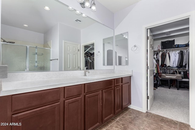 bathroom featuring vanity, tile patterned floors, and a shower with shower door