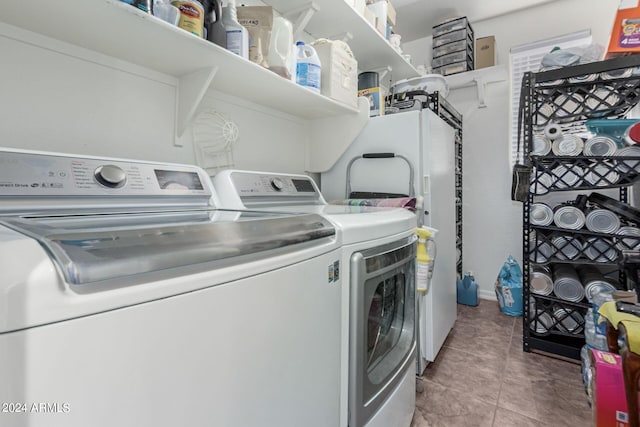 laundry area with light tile patterned flooring and washing machine and dryer