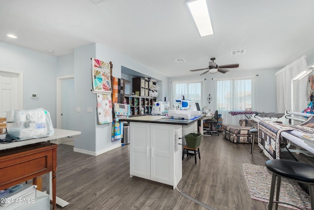 kitchen with ceiling fan, white cabinets, dark hardwood / wood-style flooring, and a center island