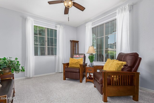 living area featuring light carpet and ceiling fan