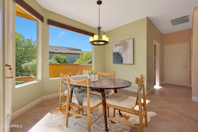 tiled dining area featuring an inviting chandelier