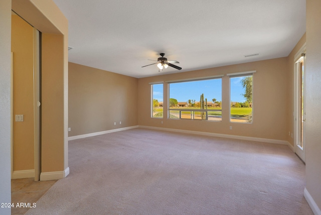 unfurnished room with light colored carpet and ceiling fan