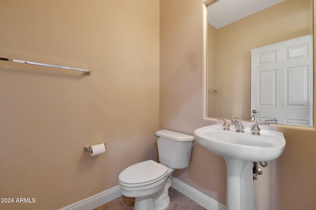 bathroom featuring toilet, tile patterned floors, and sink