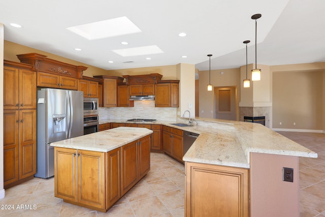 kitchen with a kitchen island, kitchen peninsula, stainless steel appliances, sink, and a skylight