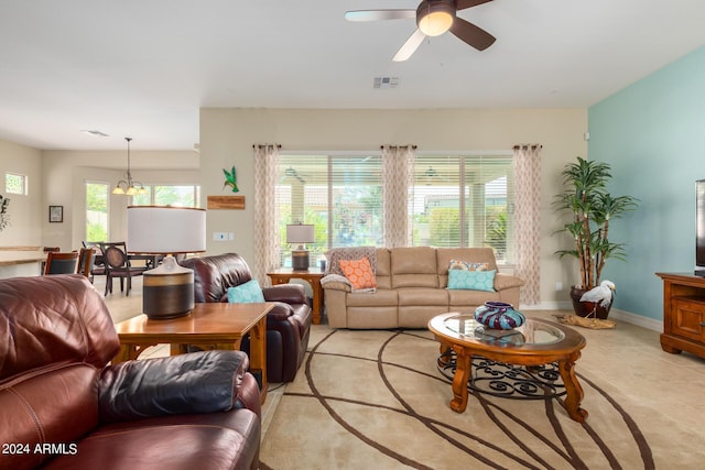 living room featuring plenty of natural light and ceiling fan with notable chandelier