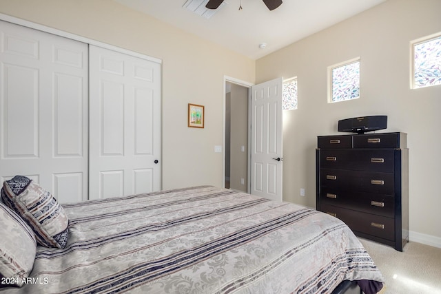 carpeted bedroom featuring ceiling fan and a closet