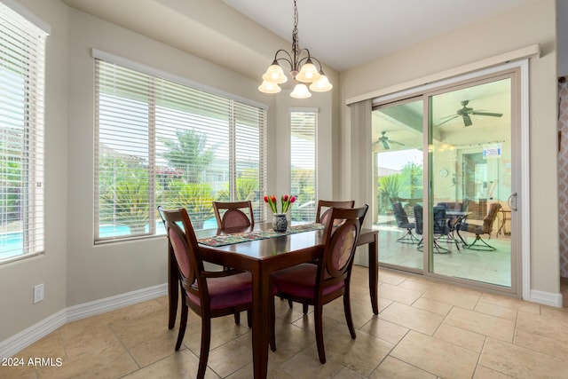 tiled dining area with ceiling fan with notable chandelier and a wealth of natural light