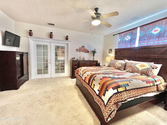 bedroom with light colored carpet, a textured ceiling, ceiling fan, and french doors