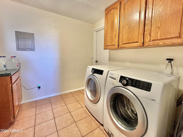 laundry area featuring cabinets, washing machine and dryer, light tile patterned flooring, and a textured ceiling