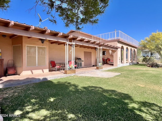 back of house featuring a patio area, a balcony, and a lawn