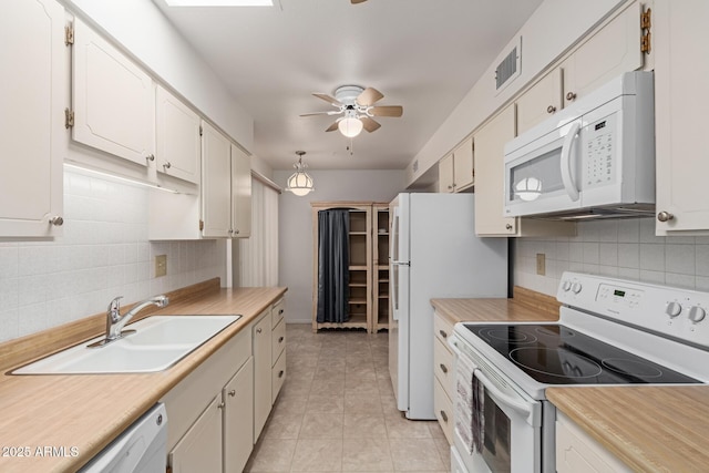 kitchen featuring white appliances, a ceiling fan, visible vents, a sink, and light countertops