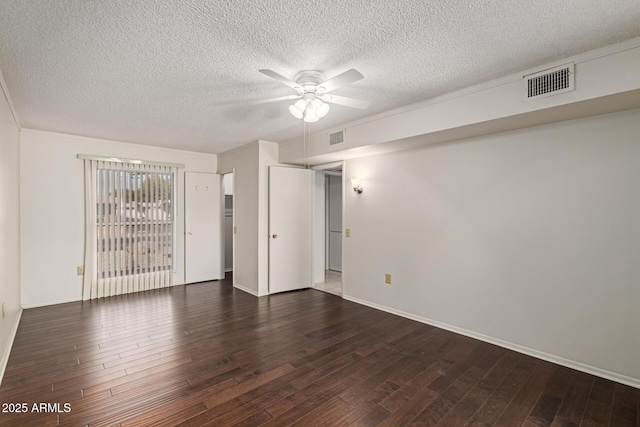 empty room featuring visible vents, a textured ceiling, wood finished floors, and a ceiling fan
