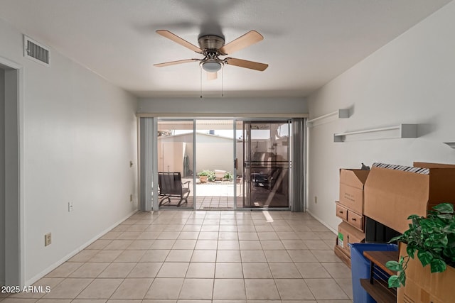 interior space featuring light tile patterned floors, visible vents, baseboards, and ceiling fan