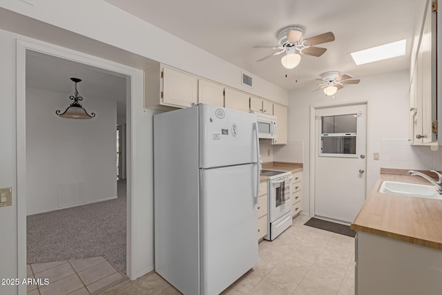kitchen with white appliances, visible vents, a sink, light colored carpet, and backsplash