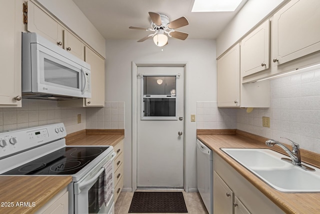 kitchen with backsplash, ceiling fan, light countertops, white appliances, and a sink