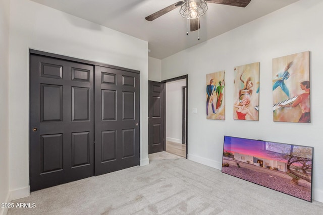 bedroom featuring light carpet, ceiling fan, and a closet