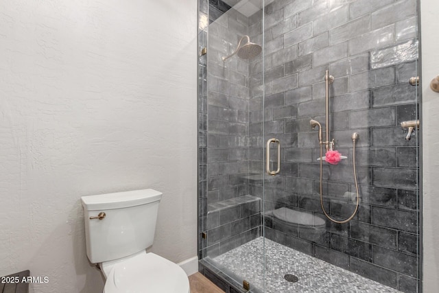 bathroom featuring an enclosed shower and toilet