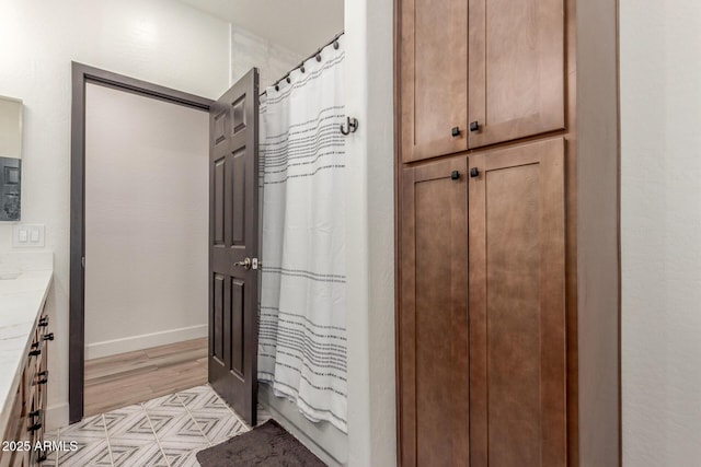 bathroom featuring vanity, wood-type flooring, and shower / bath combo with shower curtain