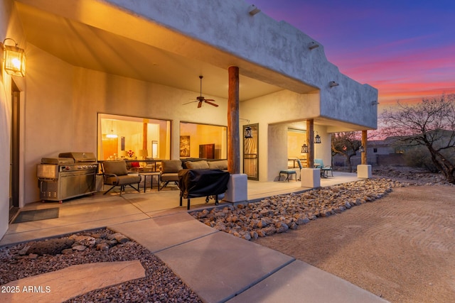 patio terrace at dusk featuring ceiling fan, a grill, an outdoor hangout area, and area for grilling