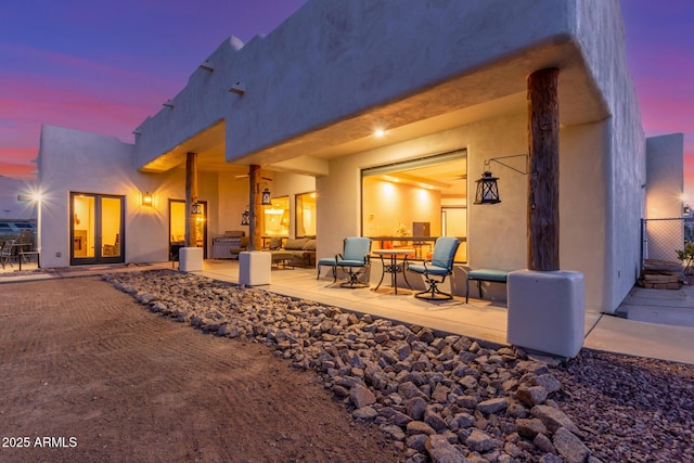 back house at dusk with a patio area