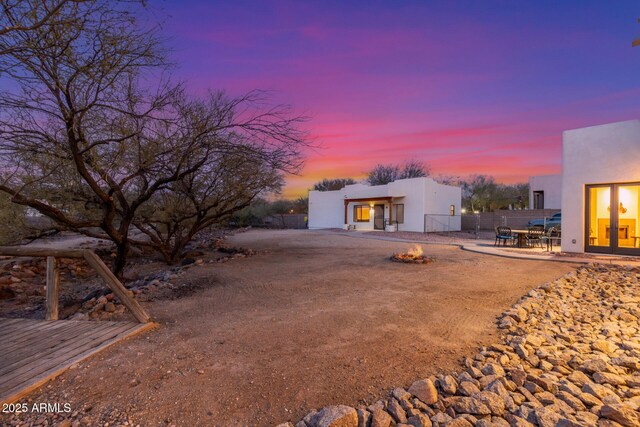 back house at dusk featuring a patio