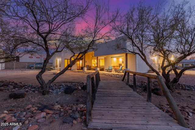 back house at dusk featuring a patio area